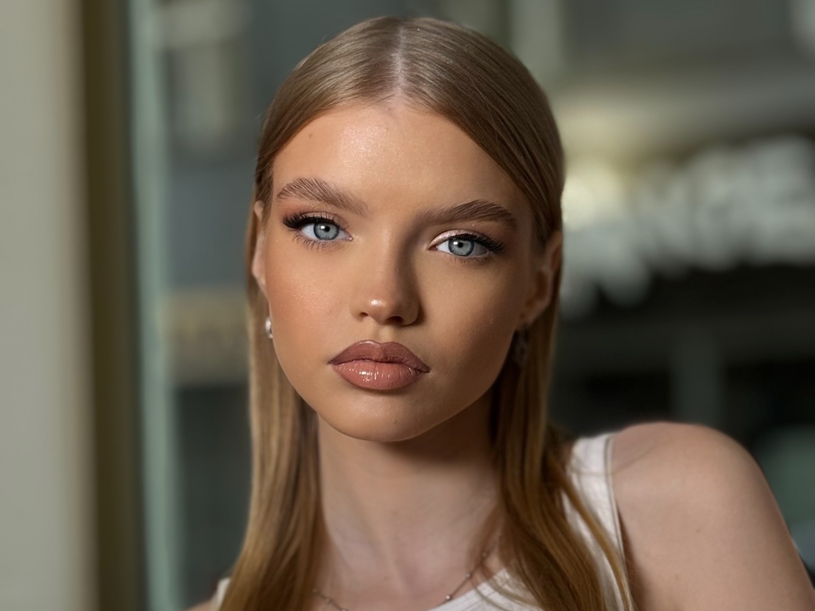 Portrét ženy s hladkými světlými vlasy a profesionálním make-upem v salonu