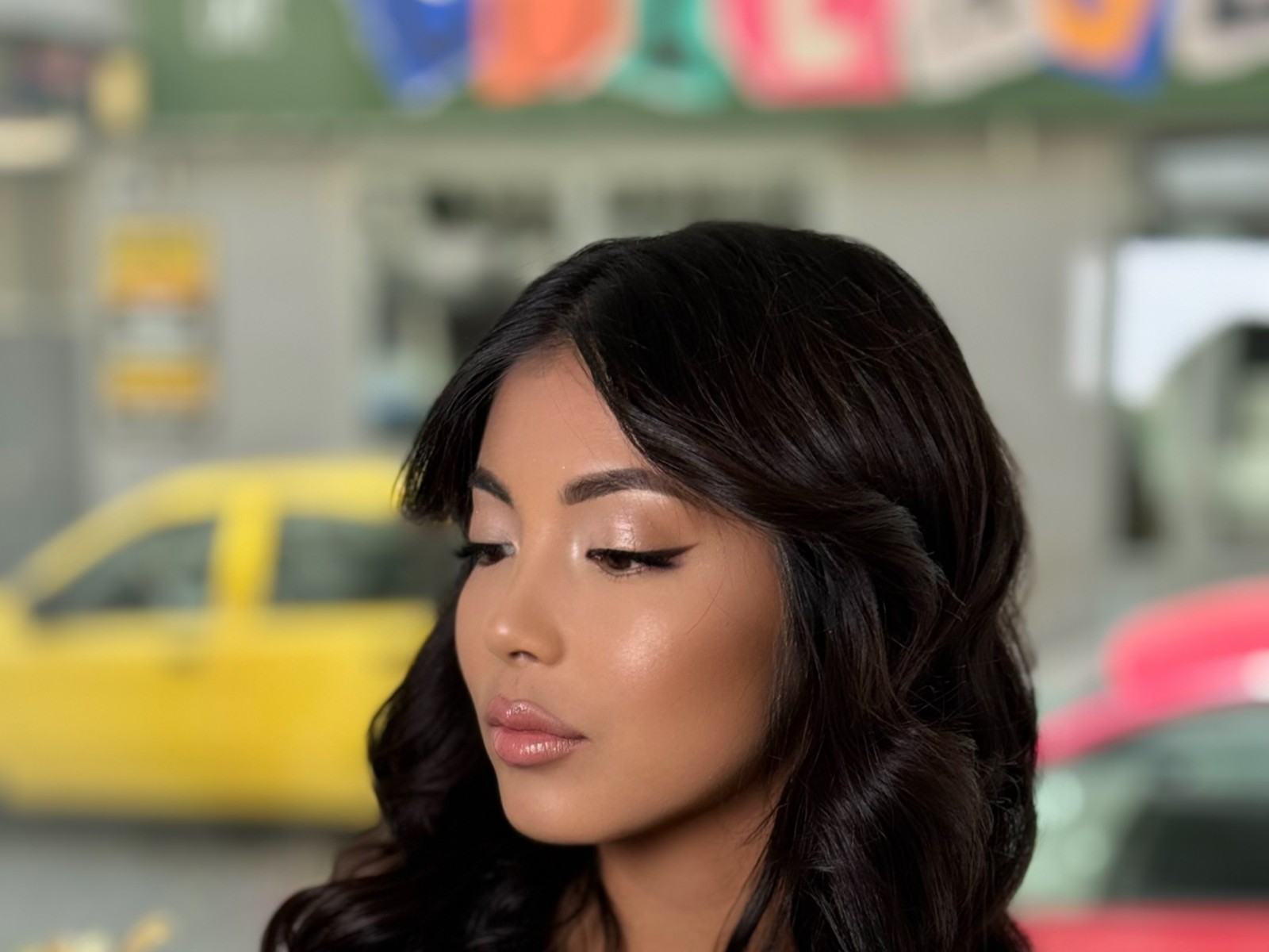 Profesionální focení kadeřnické služby: žena s dlouhými vlnitými černými vlasy a jemným make-upem